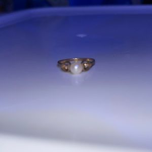 Pearl ring with hearts on each side with a small diamond in the hearts